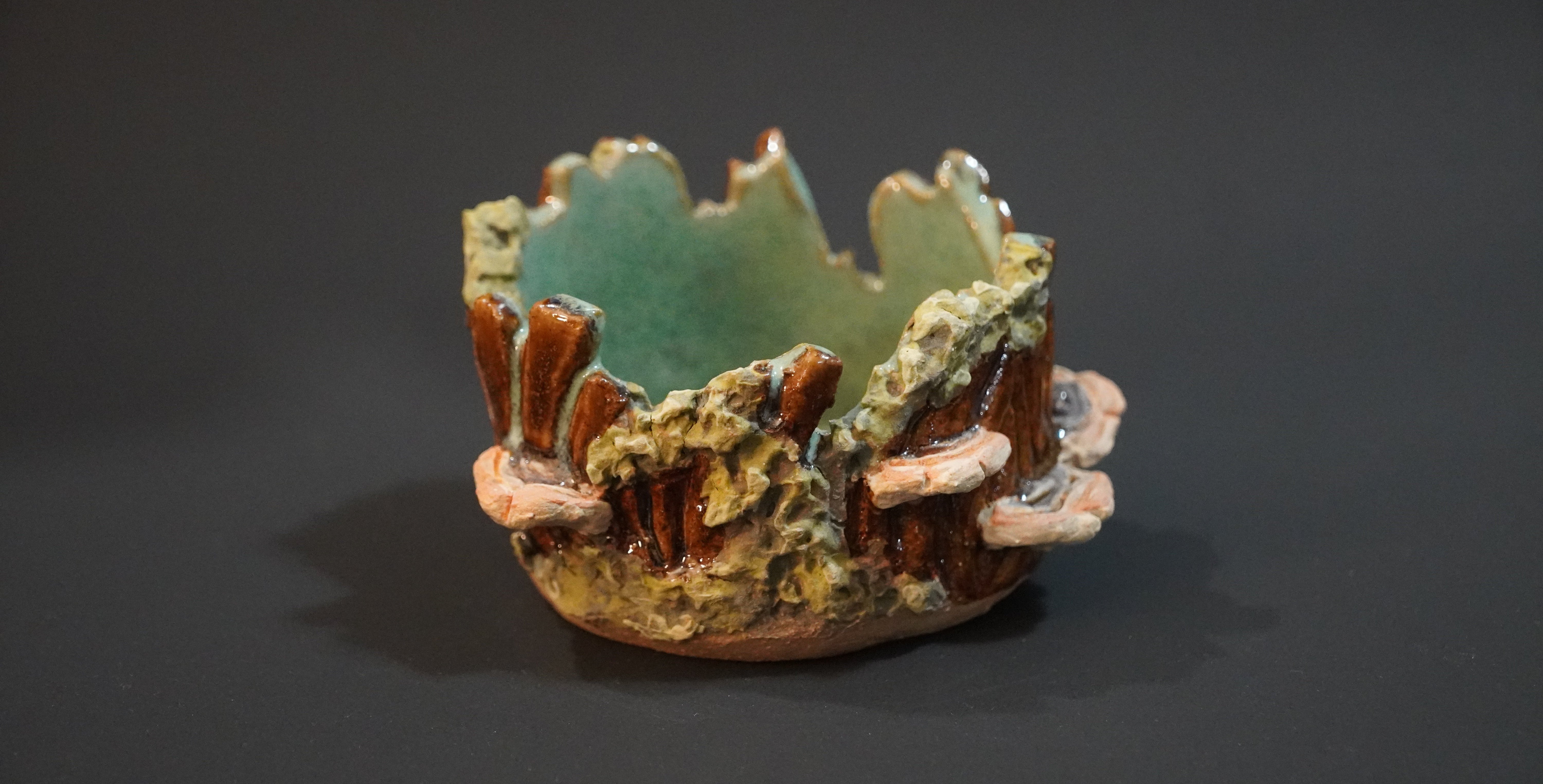 Ceramic trinket dish in the shape of a jagged tree stump covered in moss and mushrooms, with a light teal interior