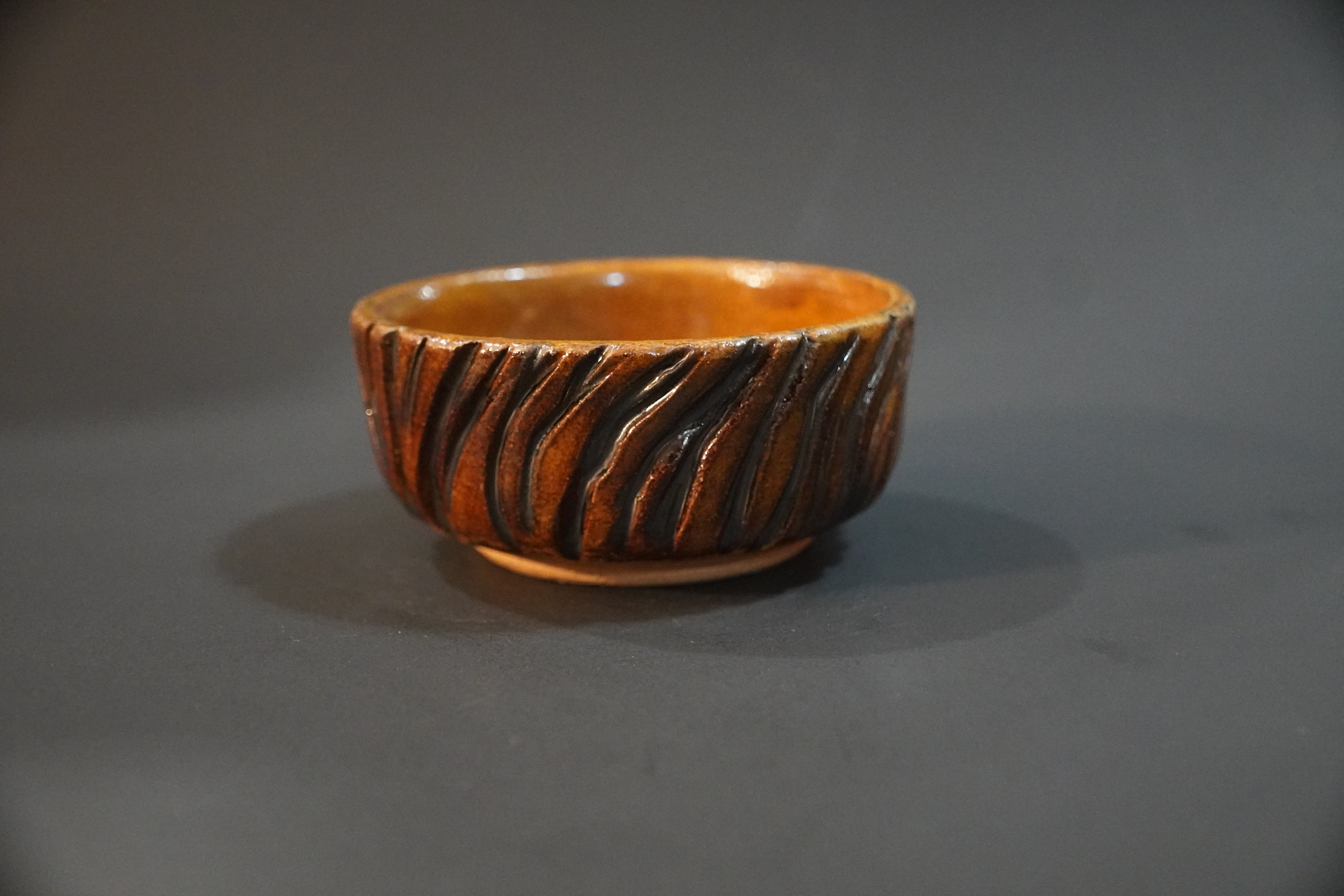 Ceramic bowl carved and glazed to resemble tree bark