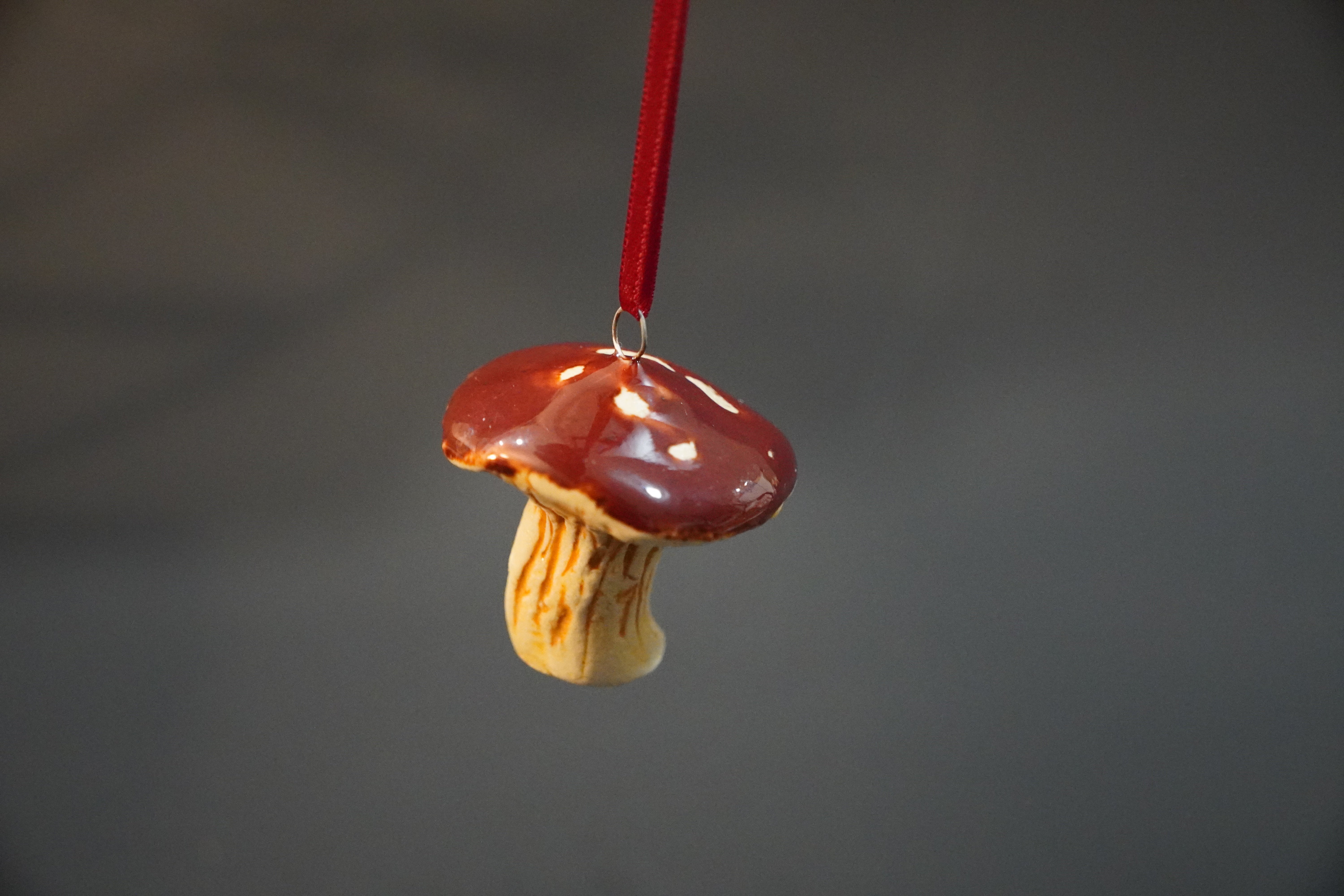 Ceramic pendant of a red-capped mushroom with white spots